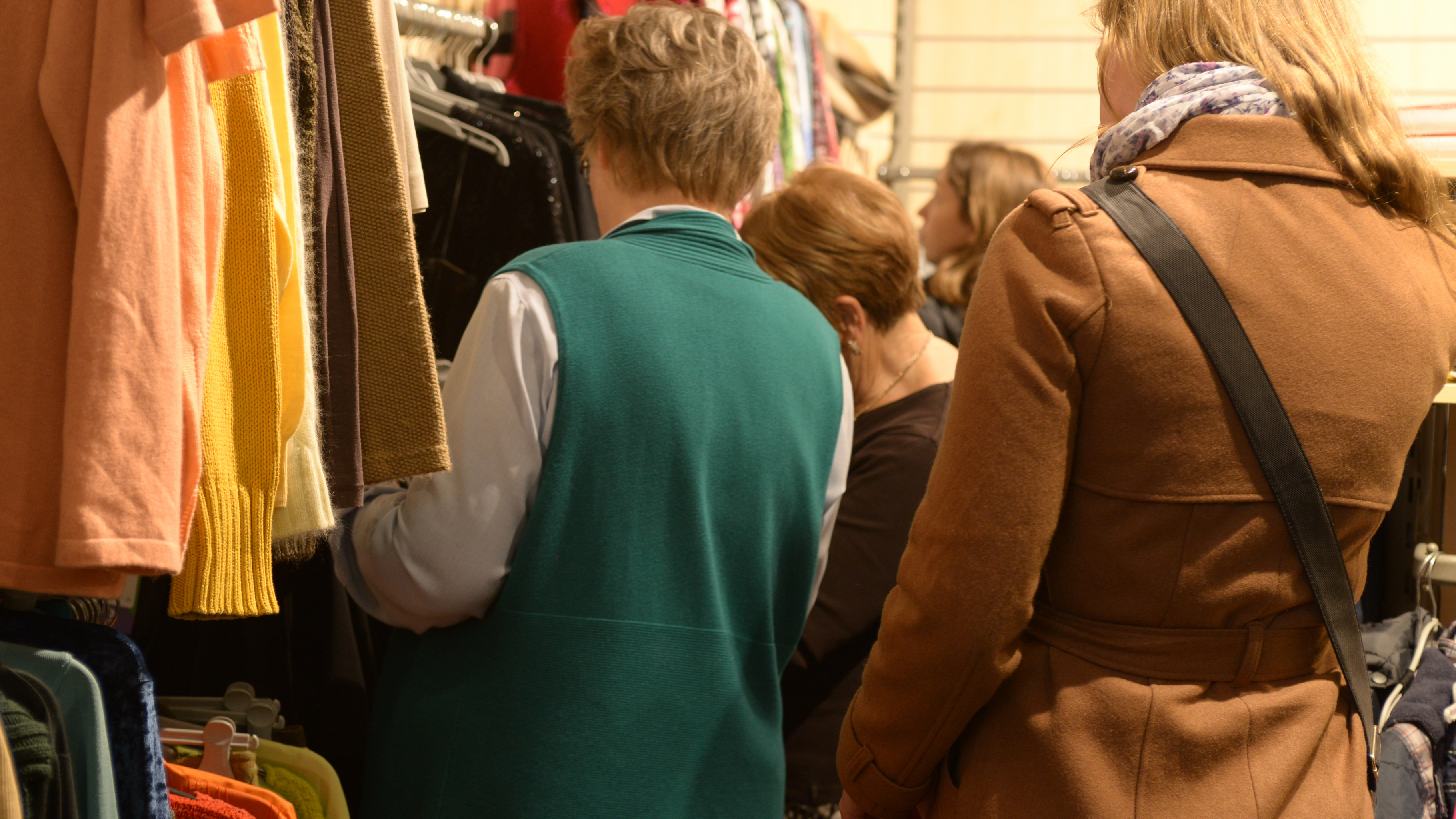 Kundschaft stöbert im Oxfam Shop durch das Kleidungsangebot.