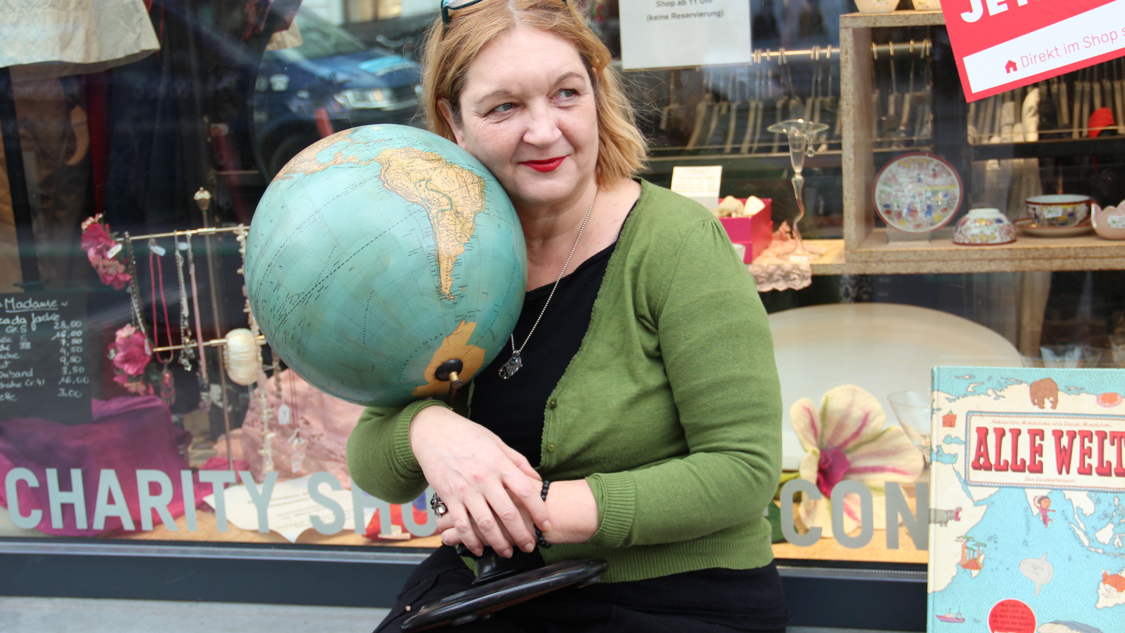 Jutta Lüttich mit dem historischen Globus vor dem Oxfam Shop Berlin-Kreuzberg