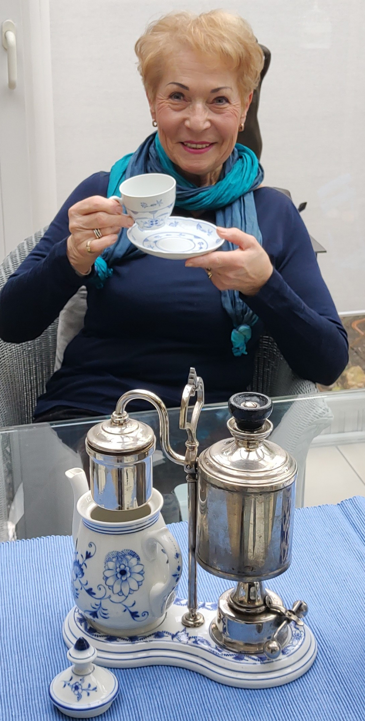 Ehrenamtliche Heidi Queirard mit der antiken Kaffeemaschine
