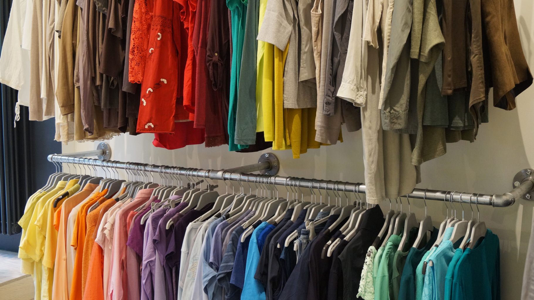 Kleidung in verschiedenen Farben im Oxfam Shop