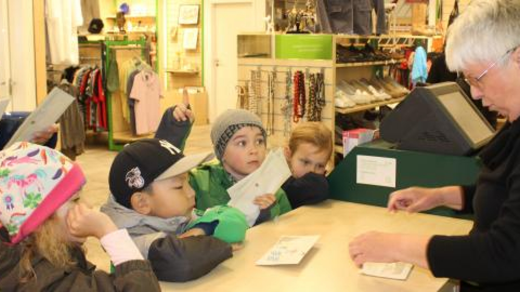 Die Kinder des Vellmenkrippe e.V. in Stuttgart übergeben der ehrenamtlichen Shop-Mitarbeiterin stolz ihr gesammeltes Geld.
