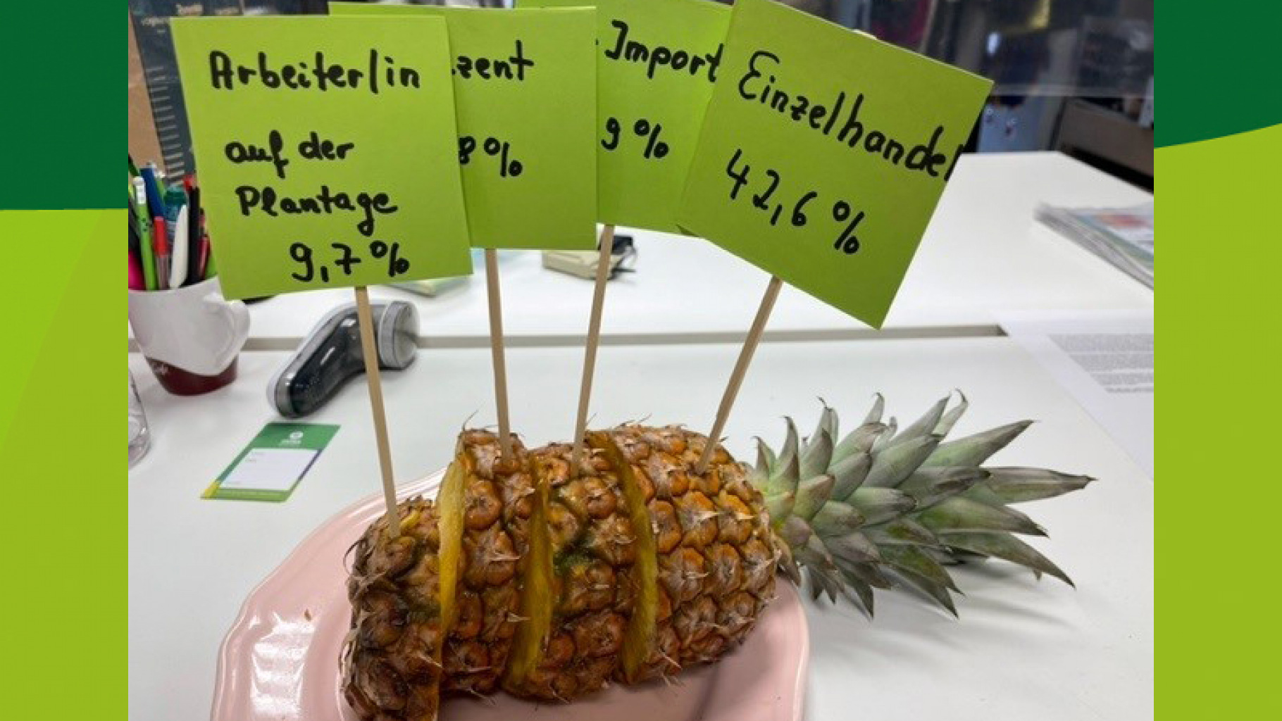 Wer verdient an der Ananas? Ehrenamtliche aus dem Oxfam Shop Bielefeld haben das mit einer echten Ananas veranschaulicht.