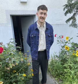Ehrenamtlicher Philipp trägt eine Jeansjacke