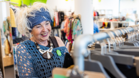 Die ehrenamtliche Mitarbeiterin Jolanta Cegielka-Kostorz sieht sich im Verkaufsraum des Oxfam Shops in Halle/Saale Secondhand-Kleidungsstücke an.