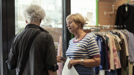 Gabriele Sarteh informiert einen Kunden im Oxfam Shop Bonn über Oxfams Kampagne.