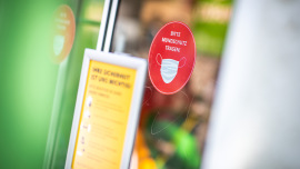 Mundschutz-Aufkleber an Eingangstür eines Oxfam Shops