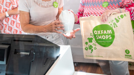 Ehrenamtliche mit Jute-Shopper an der Kasse eines Oxfam Shops