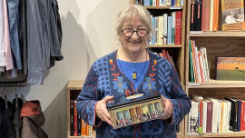 Die Ehrenamtliche Gisela mit der Box, in der sie Reklame-Sammelbilder und Mini-Bilderbüchlein aus dem 19. Jahrhundert gefunden hat.