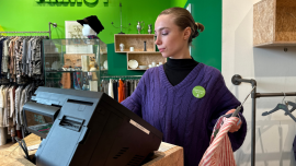 Die Ehrenamtliche Luna kassiert im Oxfam Shop.