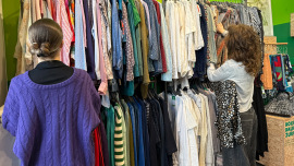 zwei junge Frauen vor einer Kleiderstange im Oxfam Shop