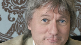 Kölner Kabarettist Jürgen Becker steht im Oxfam Shop Köln-Südstadt hinter der Kasse
