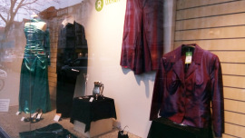 Schaufenster eines Oxfam Shops mit festlicher Kleidung