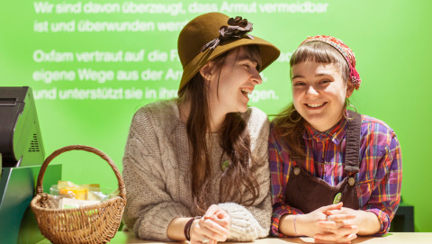 Zwei Ehrenamtliche am Empfangstresen im Oxfam Shop